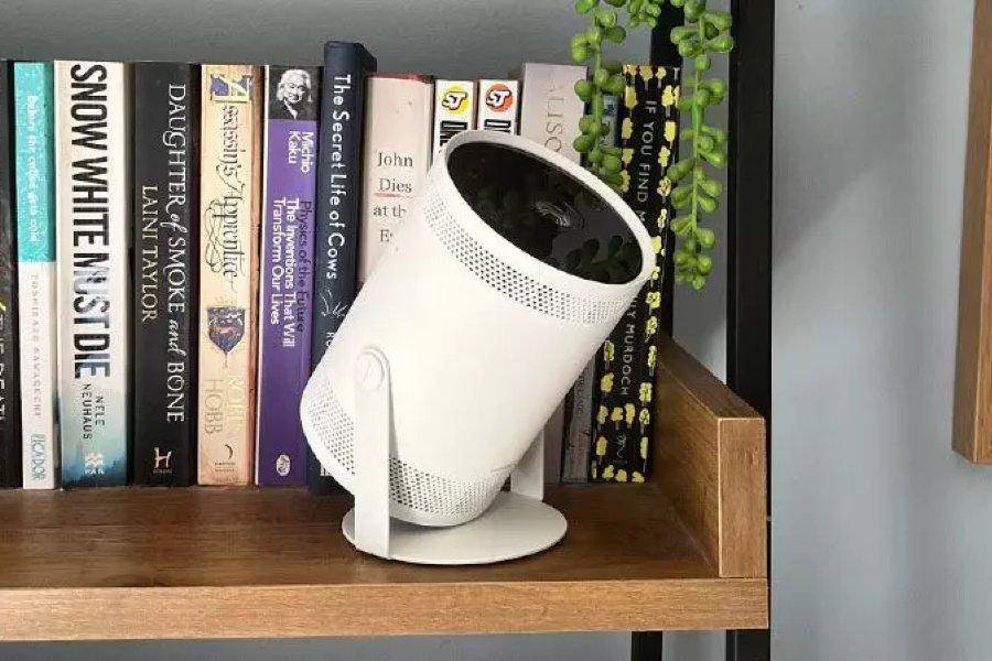 A white projector on a bookcase
