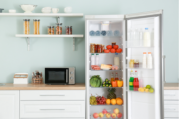 A freestanding fridge full of food open in a kitchen