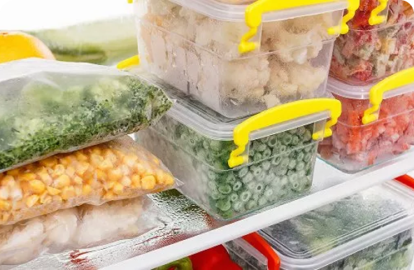 Food in Tupperware and freezer bags on a shelf in a freezer