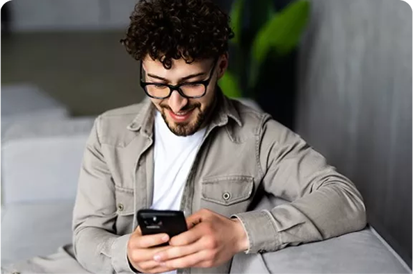 a man holding a phone whilst sitting on a sofa