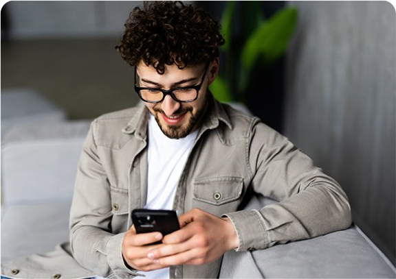 a man sitting on a couch looking at his phone