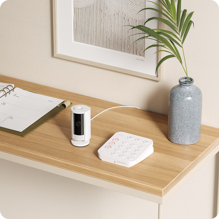 A Ring camera and smart pael on a table in a house