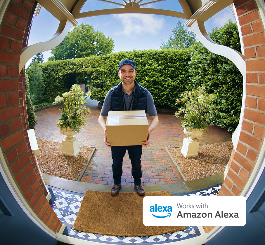 A delivery man is standing at a door holding a parcel