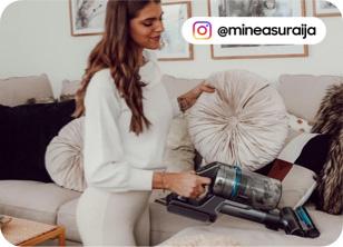 an cordless vacuum clearner being used to clean a sofa