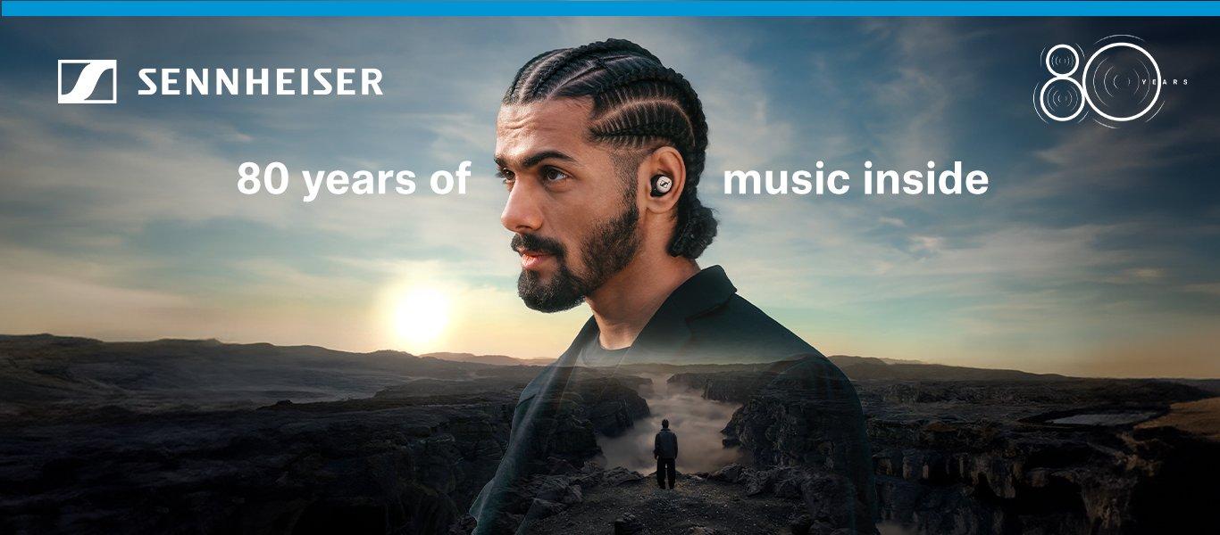 A man wearing headphones overlaid on a landscape. 80 years of music inside.