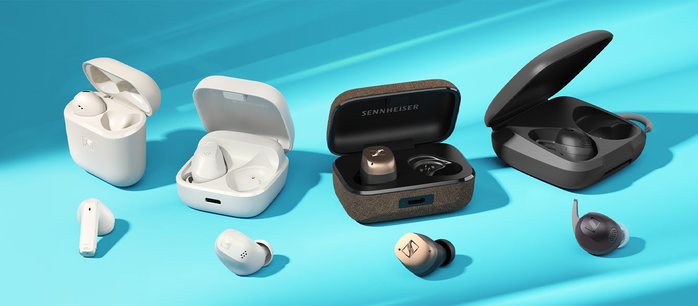 Four sets of earbuds in cases lying on a blue background