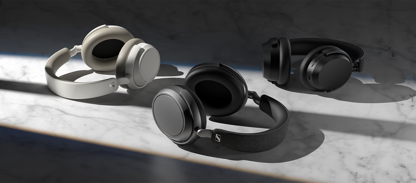 Three sets of over-ear headphones lying on a granite surface