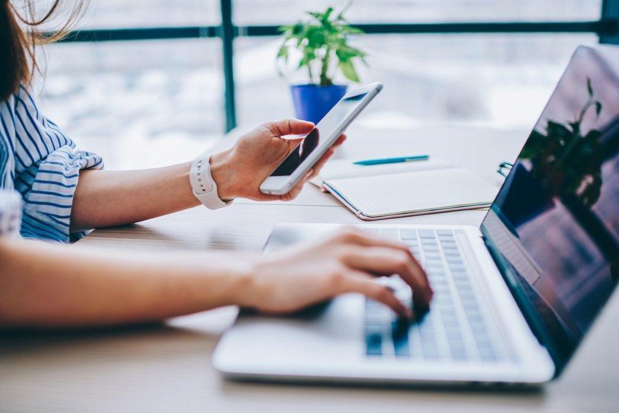 a woman sitting on a laptop with a vpn icon on the screen