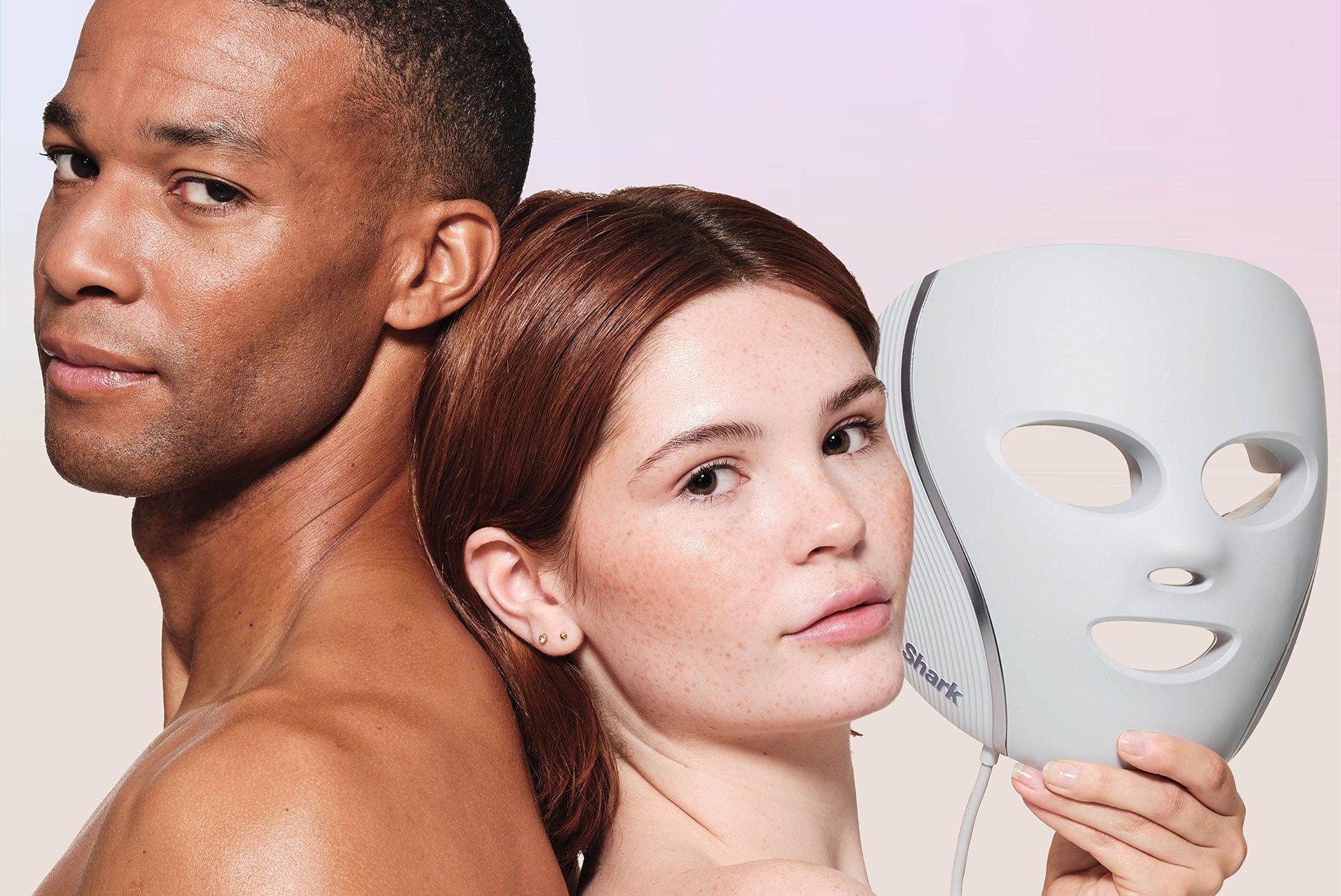 a man and woman holding a mask with a woman's face on it