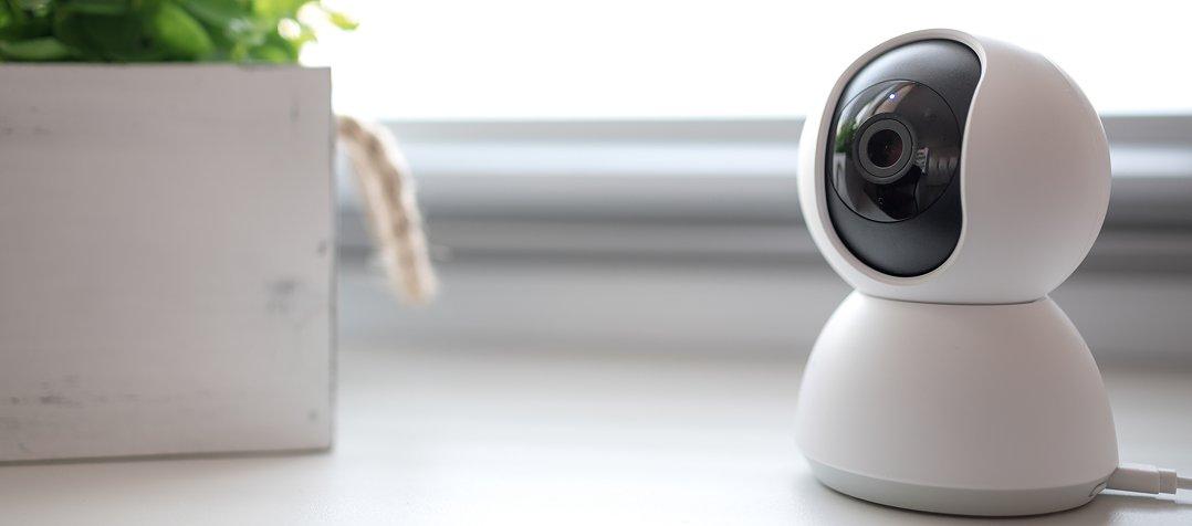 a white camera sitting on a table next to a plant