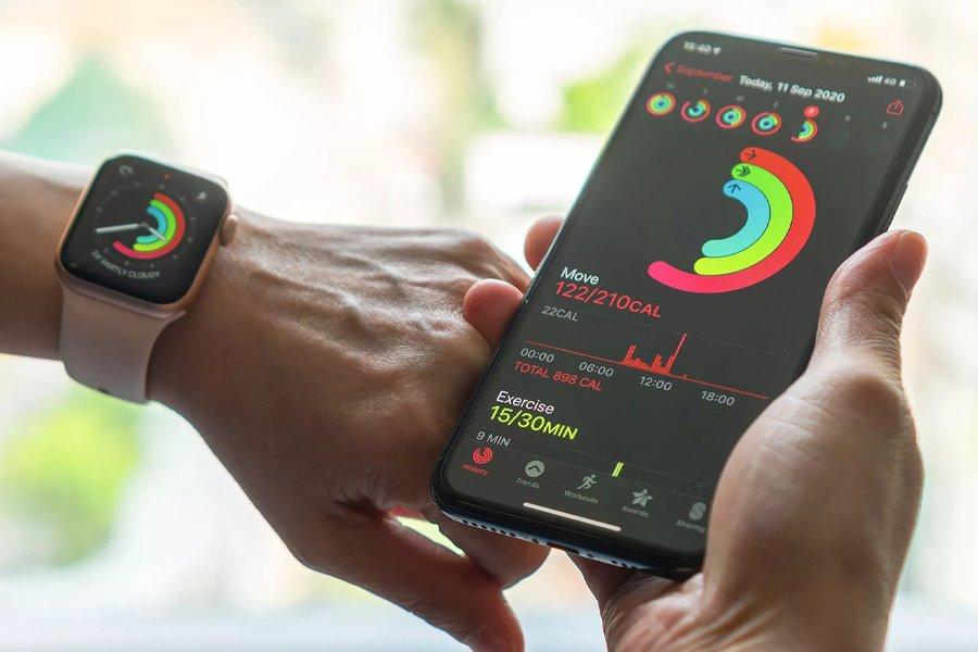 Someone holding an iPhone and wearing an Apple Watch