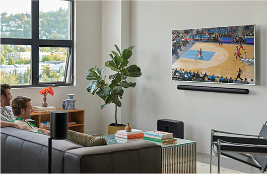 A living room with a TV on the wall, a soundbar is underneath it