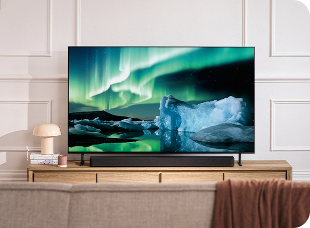 A TV on a unit in front of a sofa