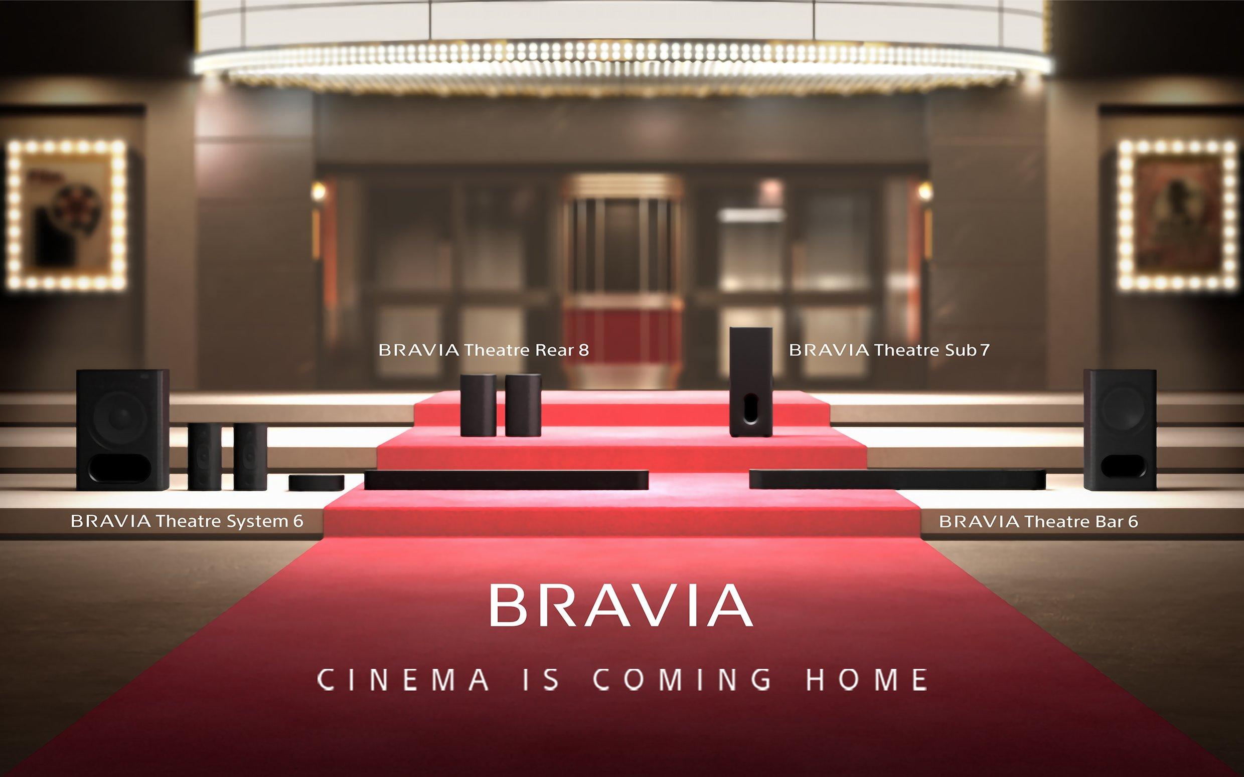 A red carpet leading up to a cinema with four soundbars on the steps
