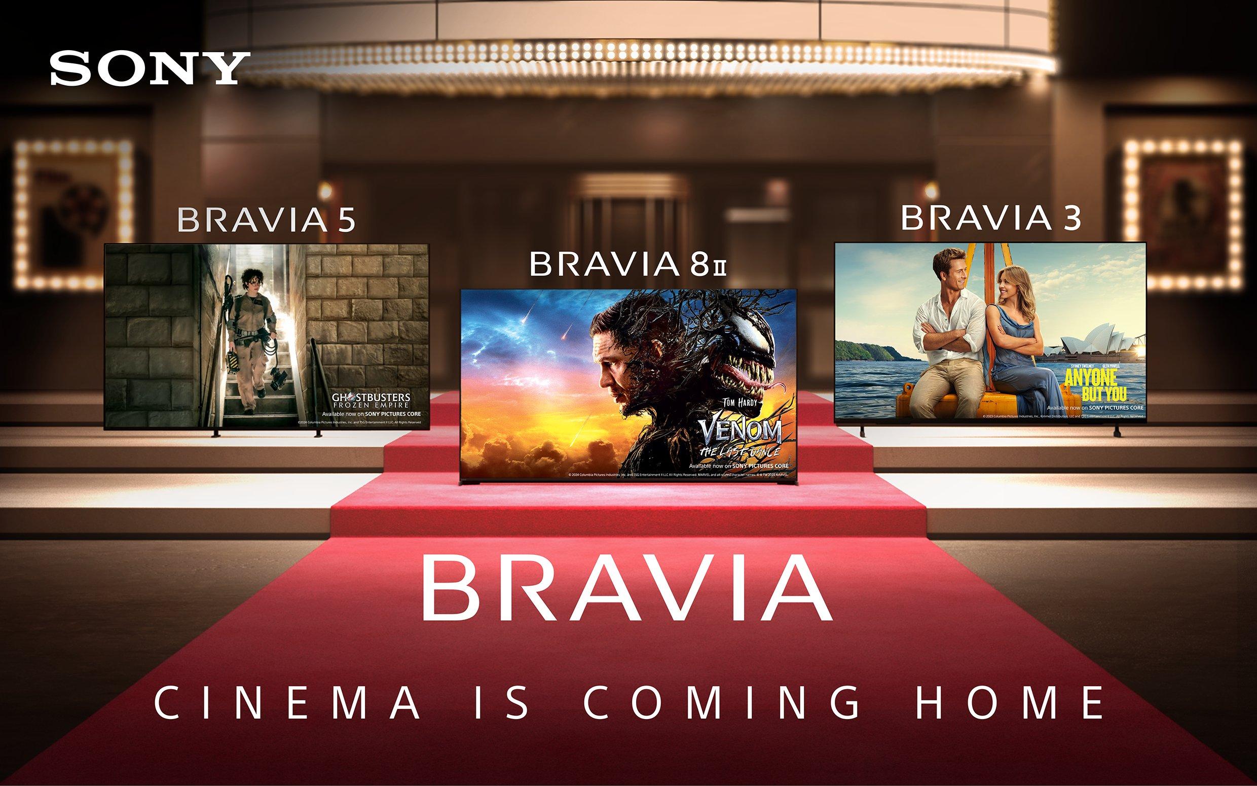 A red carpet leading up to a cinema with three TVs on the steps