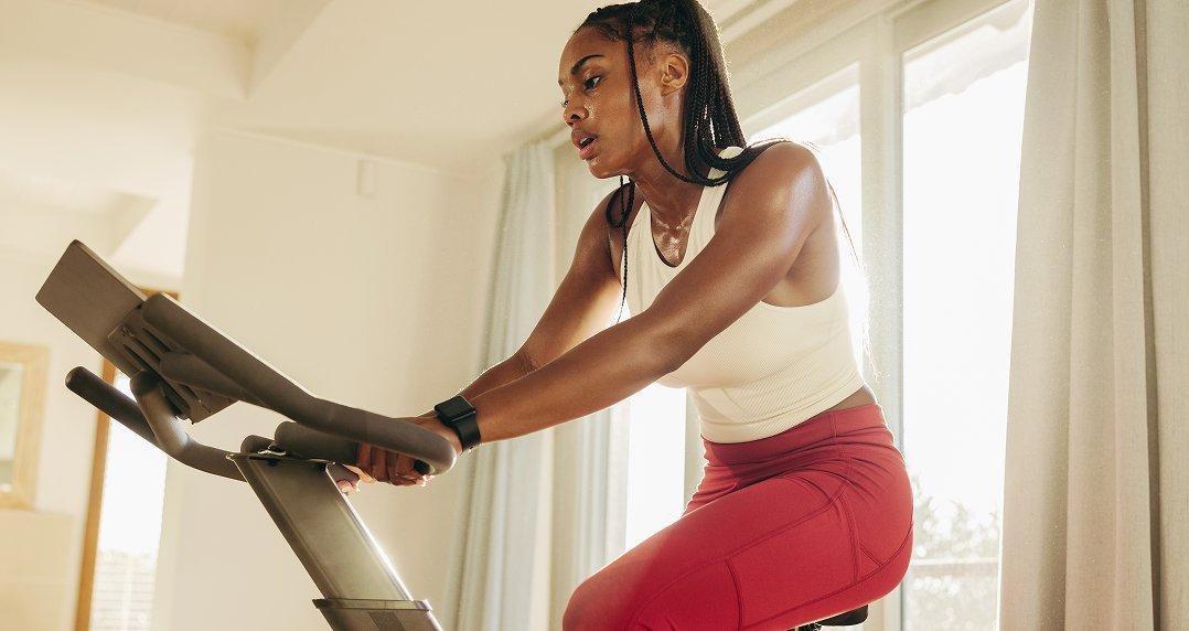 a woman in red pants riding a stationary bike in a room