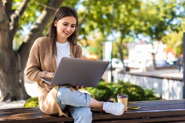 Student with a laptop outdoors