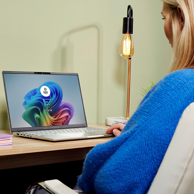 a woman sitting at a desk with a laptop open