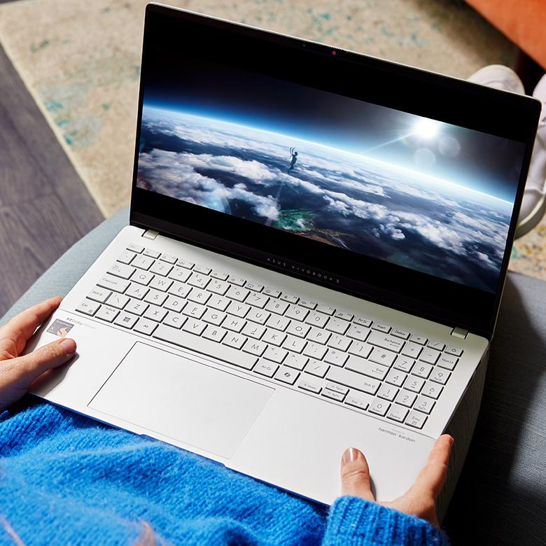 a person holding a laptop computer with a view of the earth