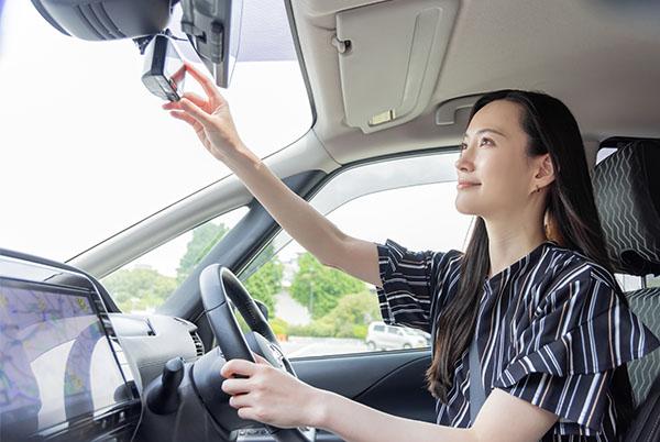 a woman sitting in a car with a cell phone in her hand