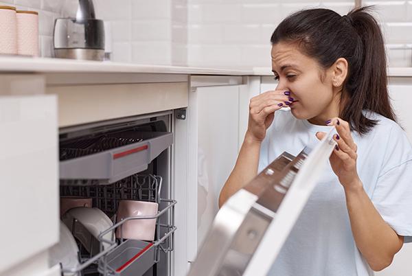 a woman in a white shirt and blue jeans wiping her nose