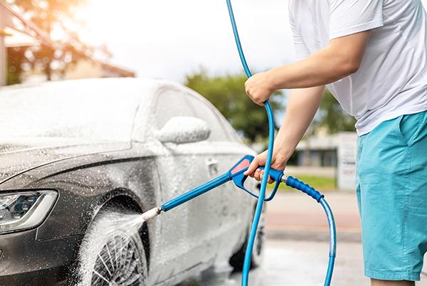 a man is washing a car with a pressure washer