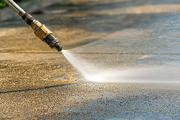 a hose spraying water on a concrete sidewalk