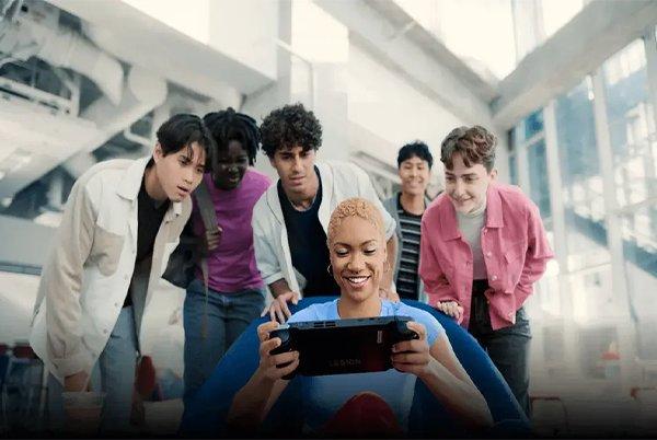 a group of people standing around a woman looking at a tablet