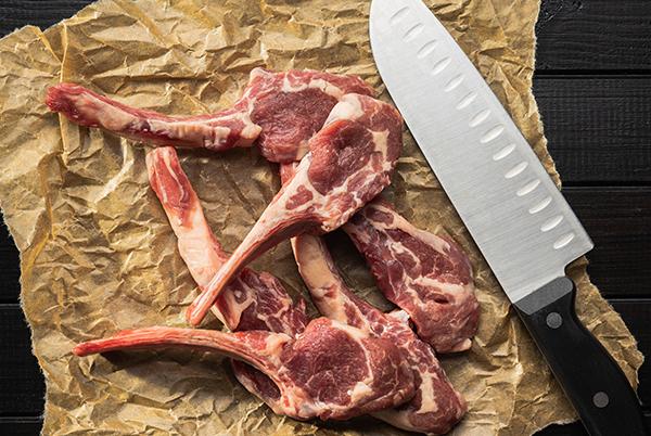 a knife and some raw meat on a piece of paper