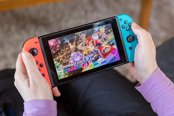 a person holding a nintendo switch game in their hands