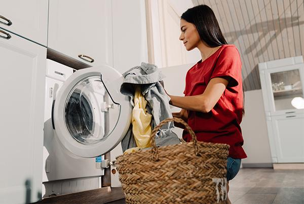 a woman in red shirt holding a basket and a laundry basket
