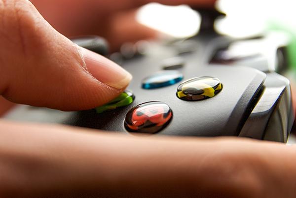 a person holding a video game controller with colorful buttons
