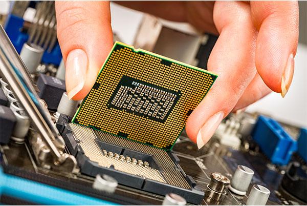 a person is holding a cpu on top of a motherboard