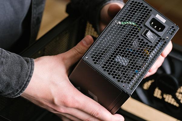 a person holding a black computer case in their hands
