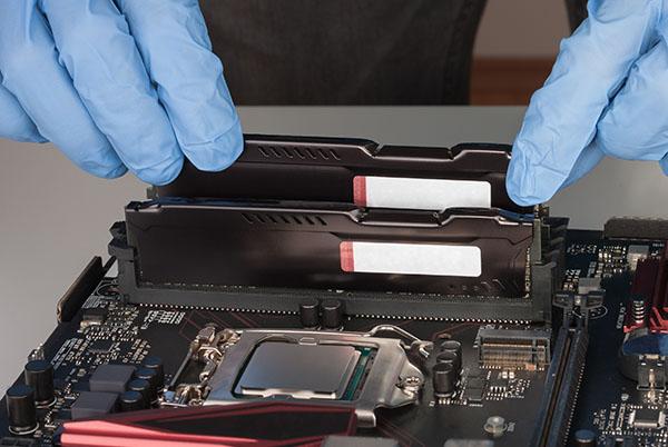 a person in blue gloves is working on a computer motherboard