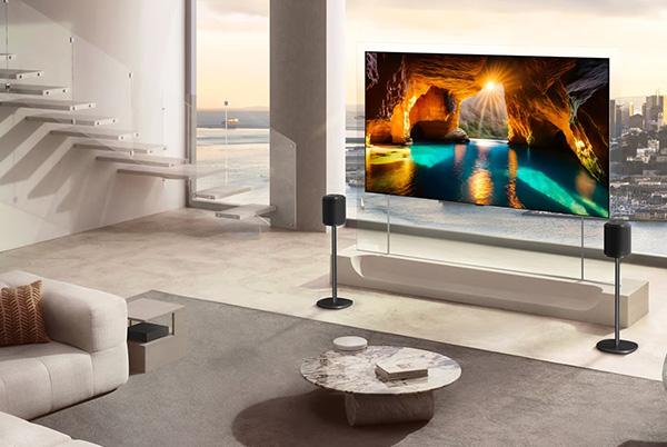 a living room with a large LG wallpaper tv and a couch