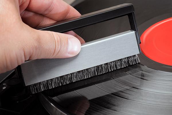 a person is using a record cleaning brush to clean a record