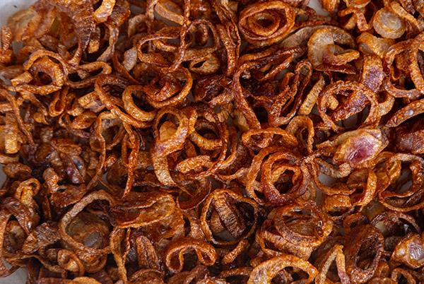 a plate of onion rings on a white table with a white table cloth