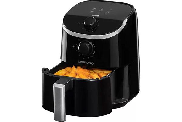 a black air fryer with some fried potatoes in it