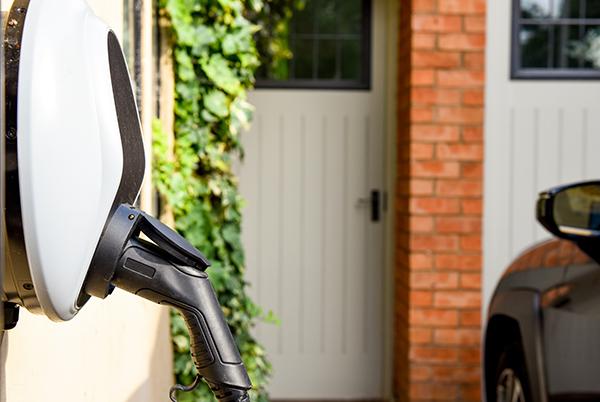 a car parked next to a house with an EV charger