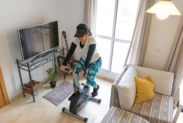 a woman riding an exercise bike in a living room
