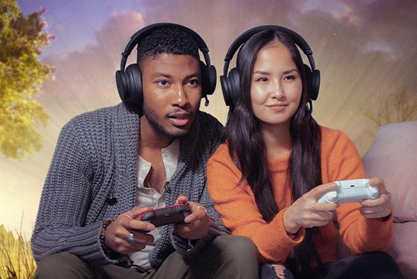 a man and woman sitting on a couch playing video games