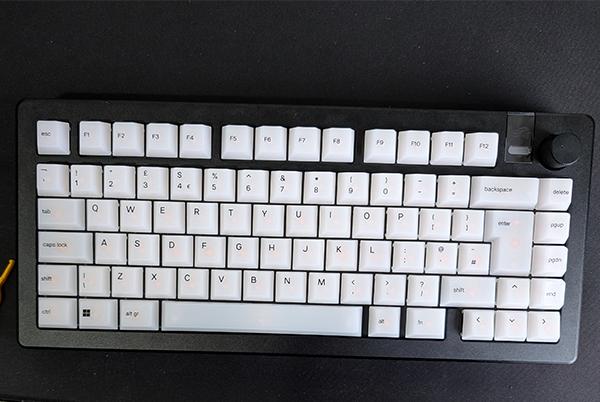 a black keyboard with white keys and a yellow pencil