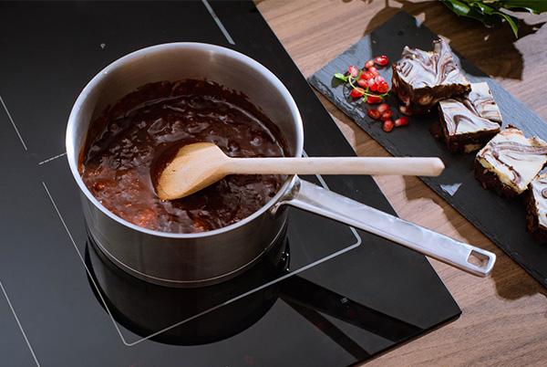 a pan of a dessert with a spoon in it on a stove