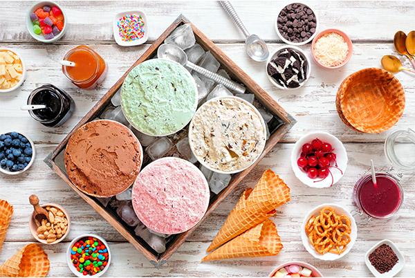 a table with bowls of ice cream, candy, and other snacks