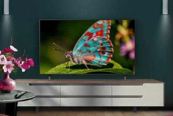 a LG NU85 50" LED 4K TV with a butterfly on it is sitting on a table