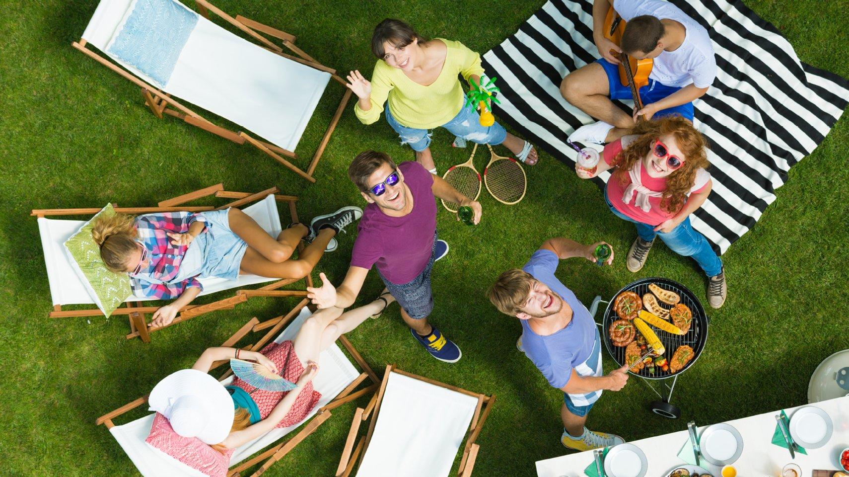 A group of people sitting on lawn chairs and having a BBQ