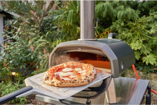 a pizza is being cooked in an Ooni Karu 2 pizza oven on a tray
