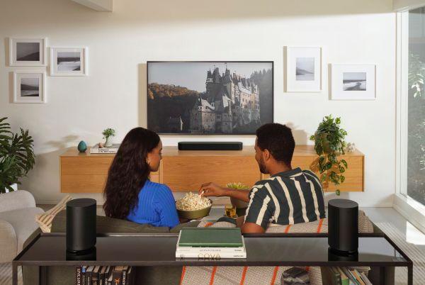 a man and woman sitting on a couch watching tv