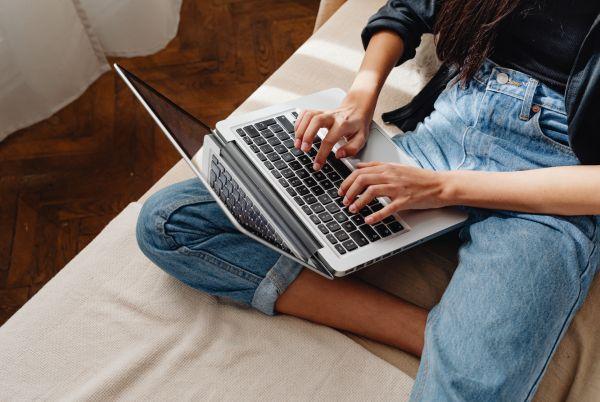 a woman sitting on a couch with a laptop computer